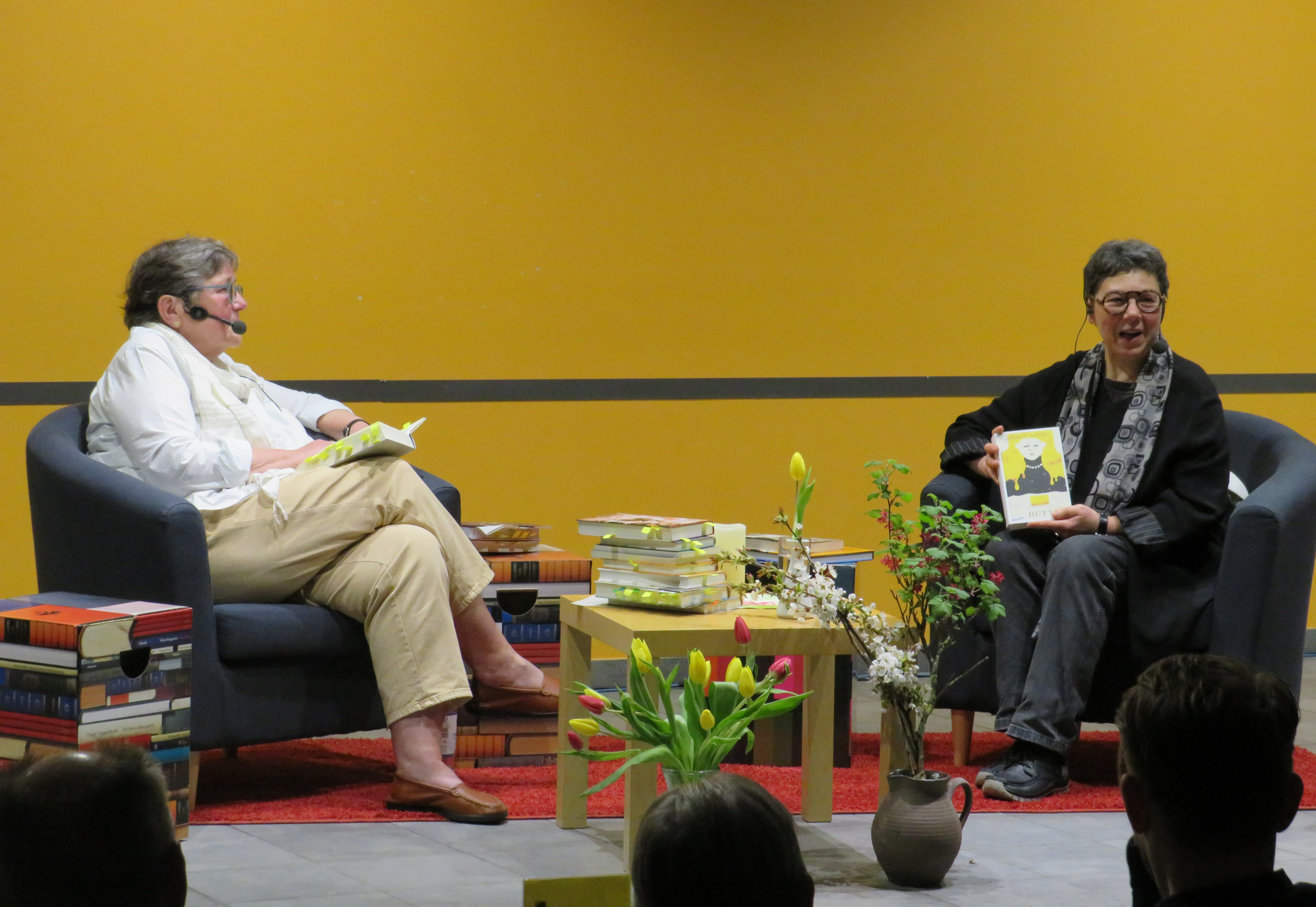  Frau Lindner zeigt lachend das gelbe Cover ihres Buches ins Publikum - das Bild wird mit Klick vergrößert 