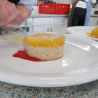 vorsichtiges Anrichten des Desserts: Mangokompott auf Milchreis - das Bild wird mit Klick vergrößert