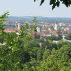 Ausblick von der Strecke durch Bäume auf die Türme von Crailsheim