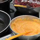 Süßkartoffelpüree und rote Zwiebeln bei der Zubereitung auf dem Herd - das Bild wird mit Klick vergrößert